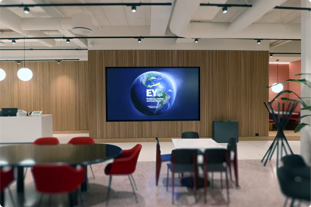 bildet viser lobbyen til EY på stortorvet 7, der en står samsung led skjerm er i sentrum. på skjermen ser du en klode og EY's logo